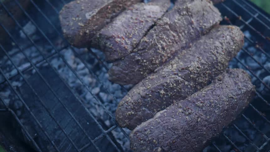 Meat cooks on a grill