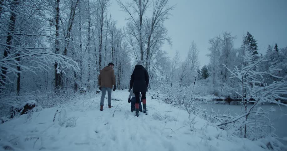 A family walks together in the snow