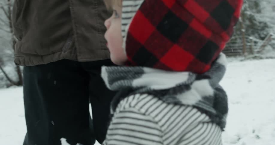 Man helps his child build a snowman