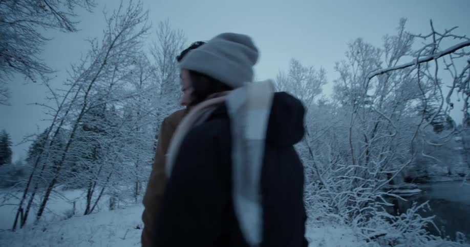 A family walks outside in the snowy woods
