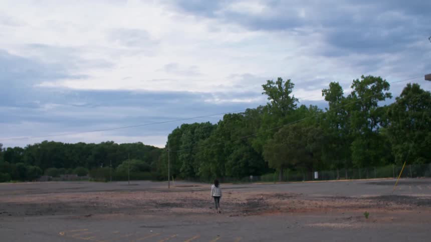 Person walking outside in the middle of a large field