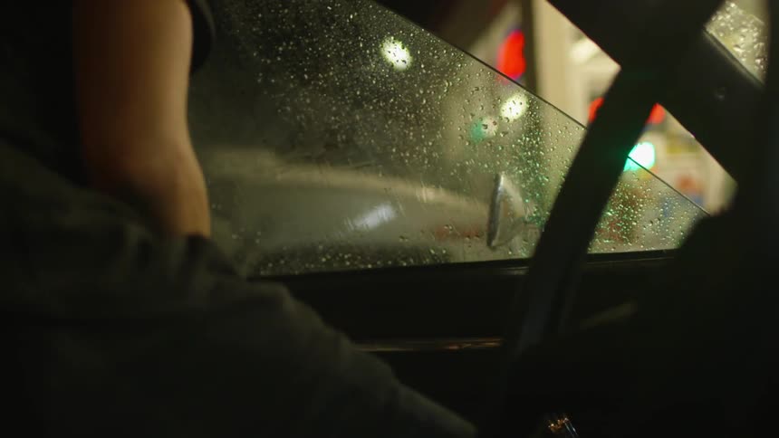 A man enters the driver seat of a car
