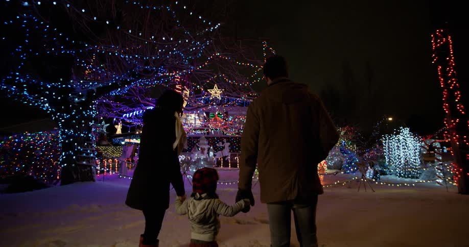 A family stands next to an elaborate christmas display