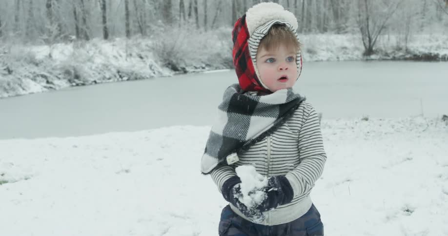 A young child plays in the snow