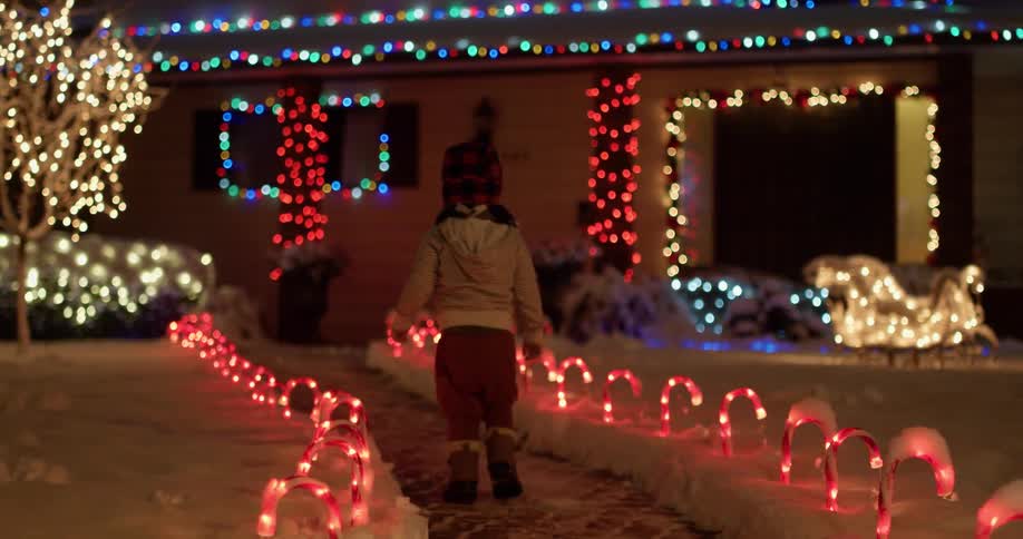 A young child walks down a house entrance lined with decorations