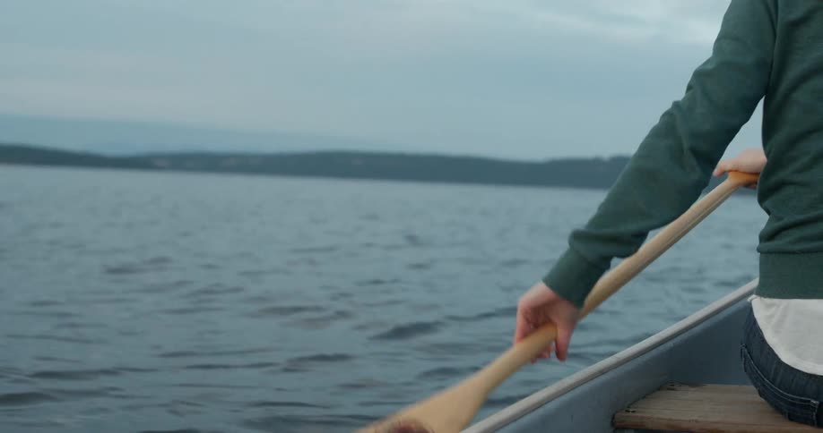 Woman paddles a boat through the water