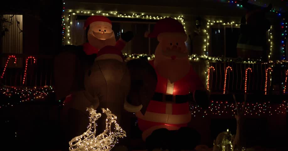 The christmas decorations in front of this home flash at night