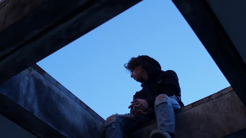 Someone is sitting on the ledge of a roof