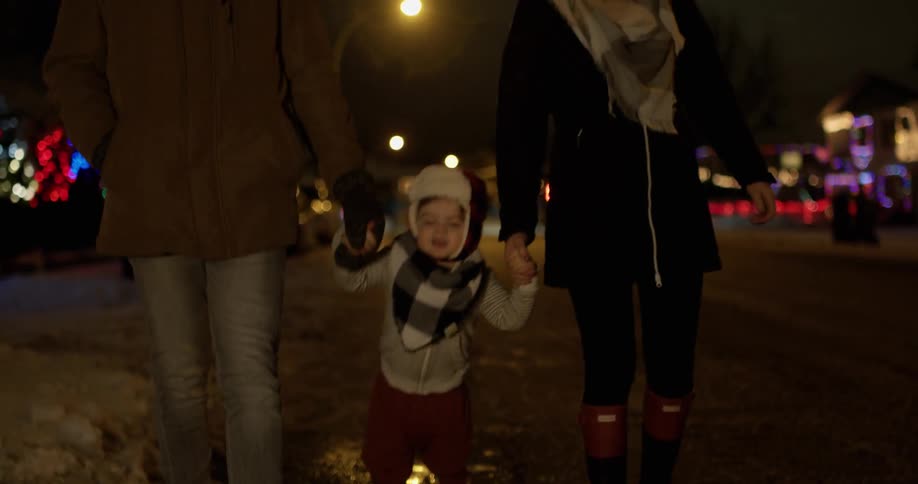 A couple walks with their child in the snow