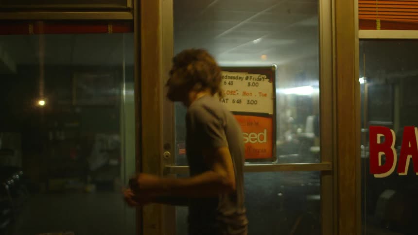 A man dances around at night smoking a cigarette