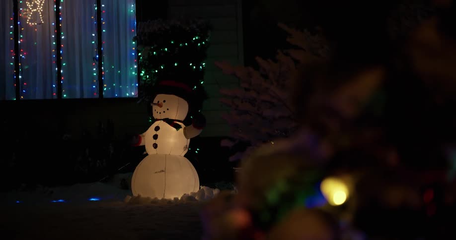 Christmas lights blink rapidly behind an inflatable snowman