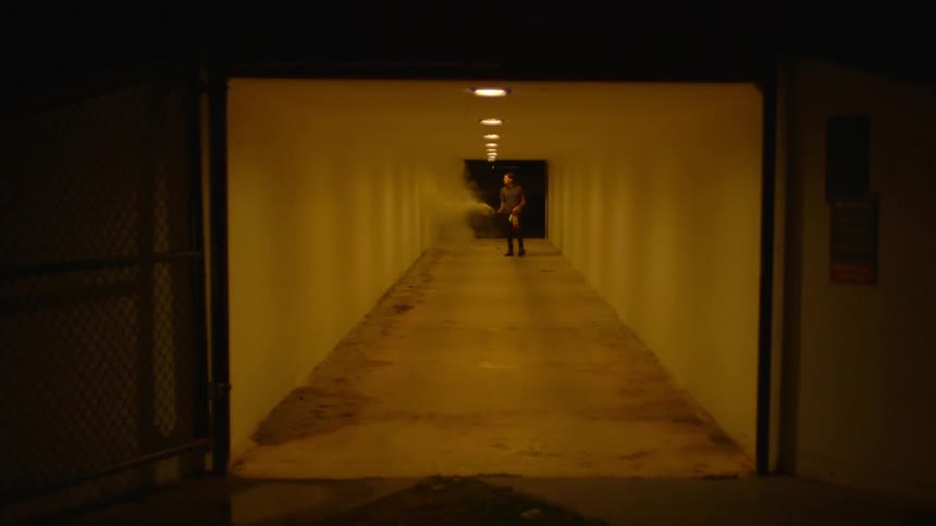 A man sprays a fire extinguisher in a tunnel at night