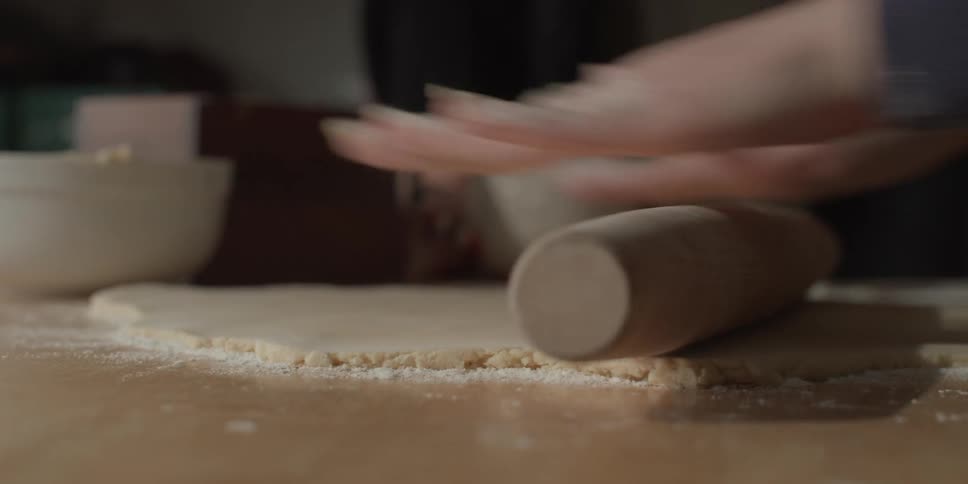 Dough being rolled with a rolling pin