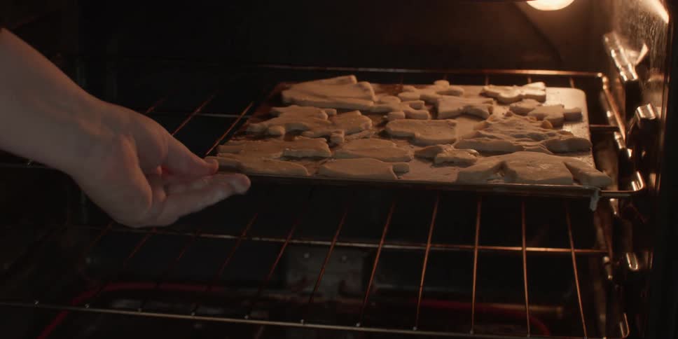 Baking sheets full of cookies are put into the oven