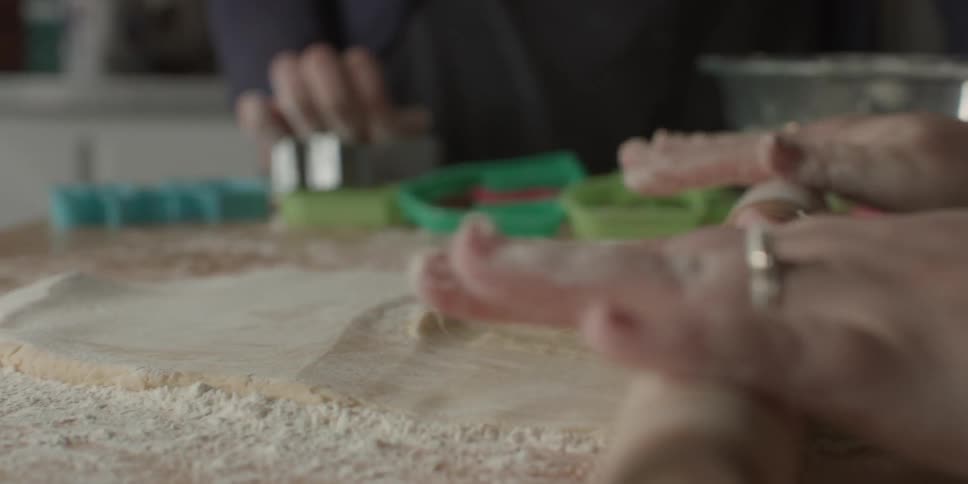 A person rolls out dough with a rolling pen