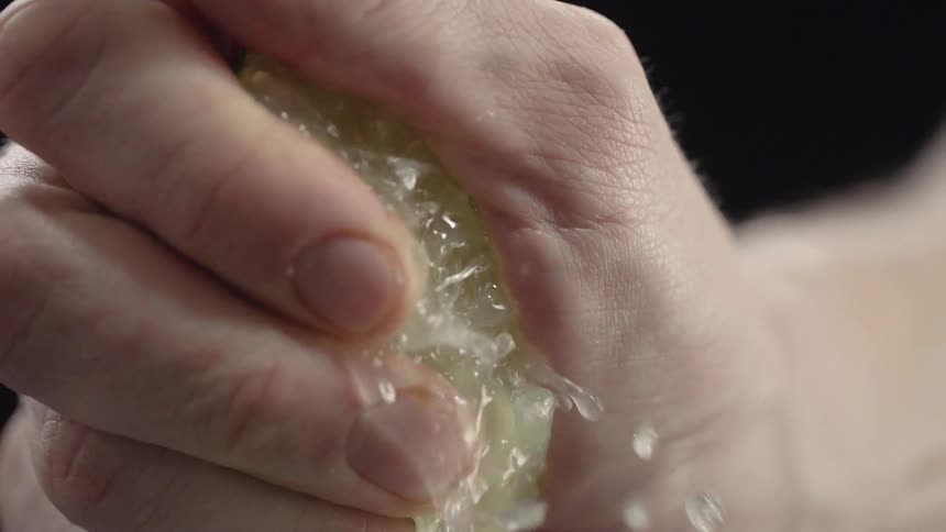 A man squeezes juice from a lime