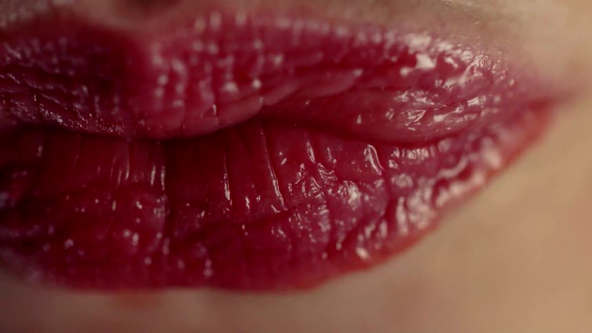 A person wearing pink lipstick presses her lips together