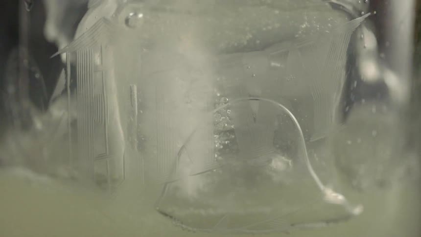 Liquid is poured over ice in a glass