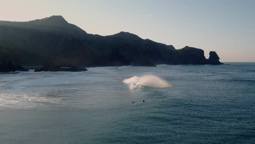 Surfers are in the ocean and waves are crashing around them