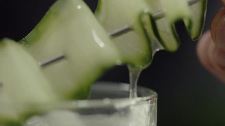 A garnish is pulled out of a cocktail then placed back in
