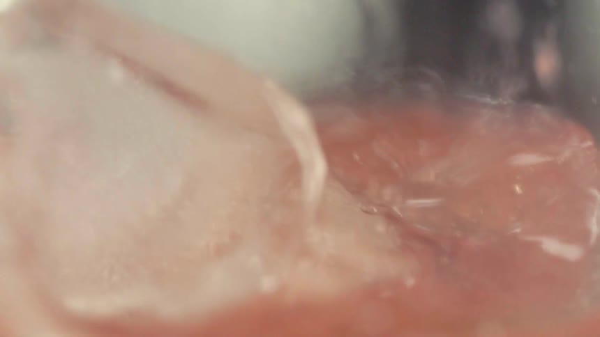 Ice is dropped into a pink drink