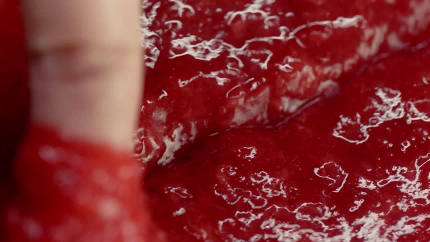 A person scoops up jam with their finger