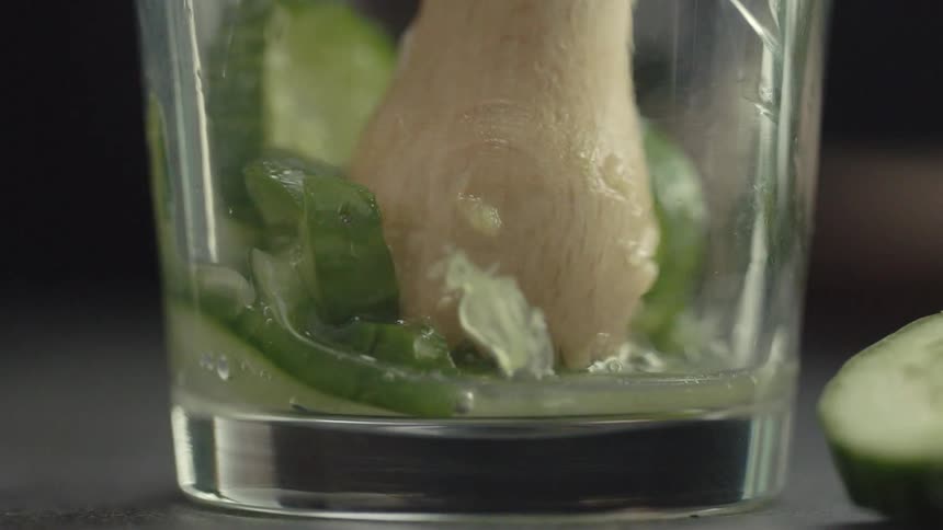 Limes being smashed in a cup