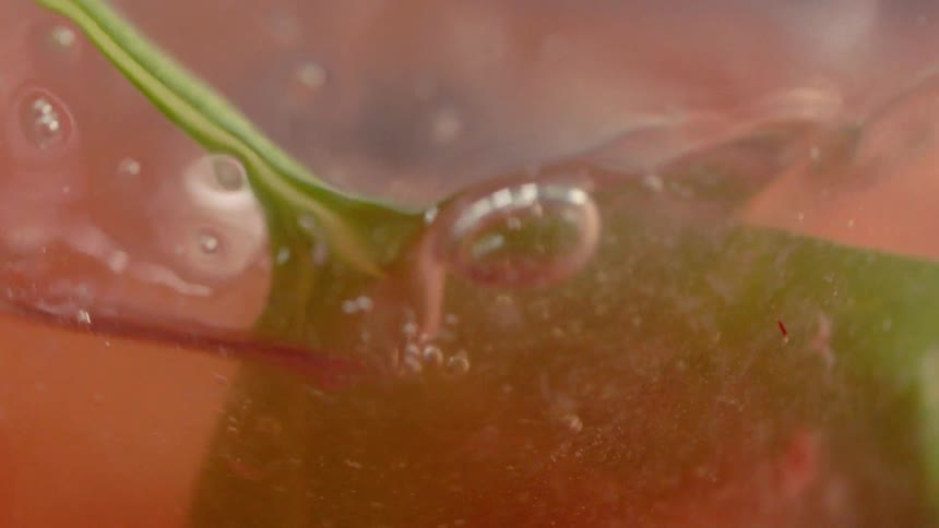 Ice is dropped into a pink drink