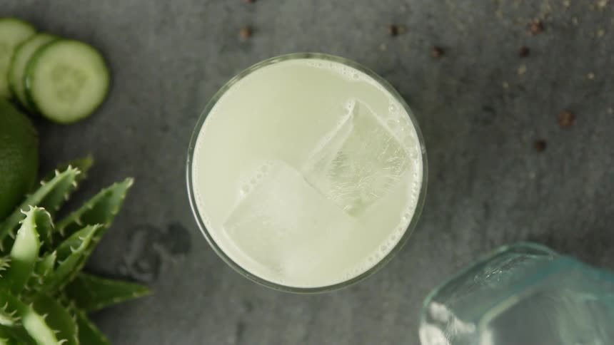 A yellow drink with ice in it