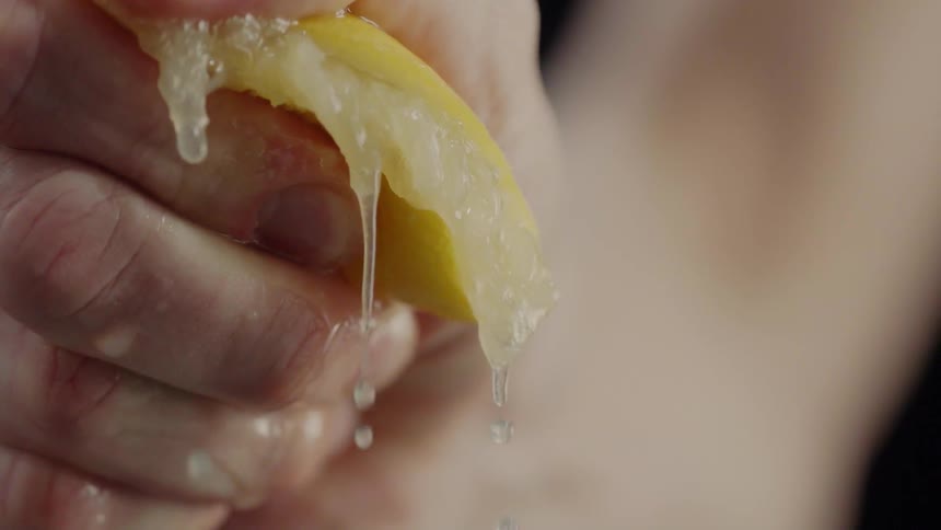 Someone squeezes a lemon
