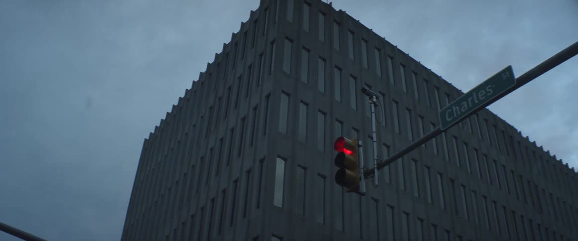 A stoplight illuminates red in front of a city building