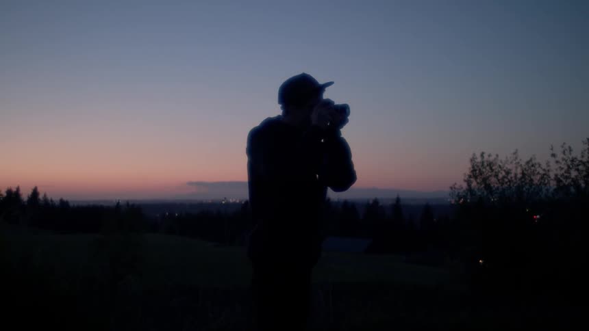 A man turns and takes a picture at dawn