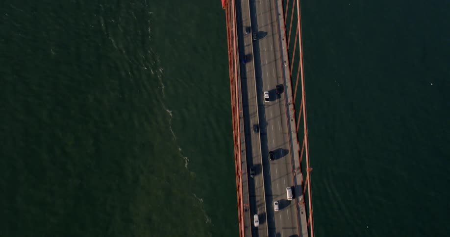 The cars travel fast over the bridge crossing the water