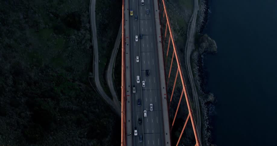 Many cars travel over this large bridge; Golden Gate