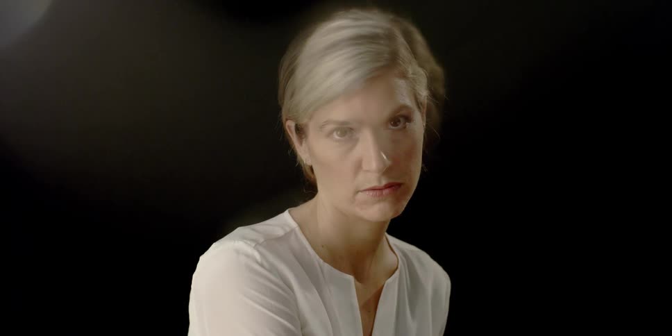 A blond woman in a dark room