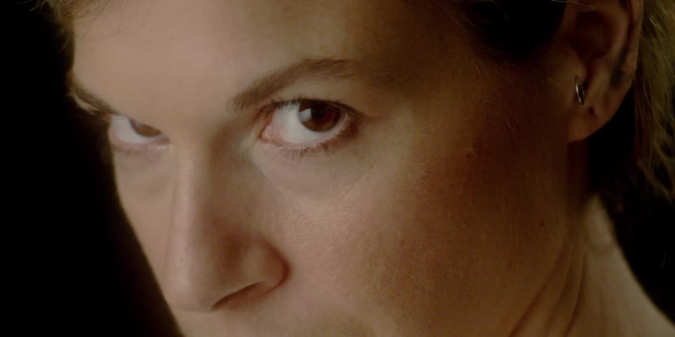 A woman looks down then directs her gaze forward