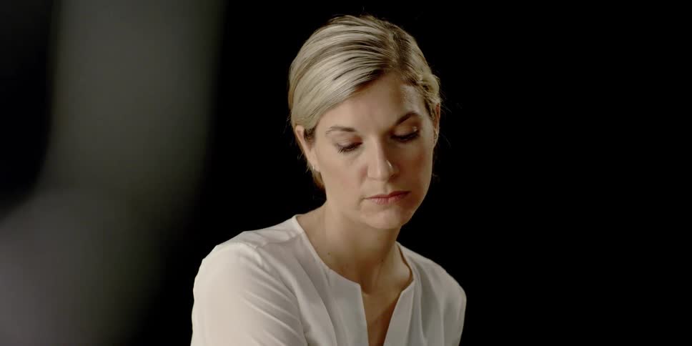 A woman shifts her body as she gazes forward