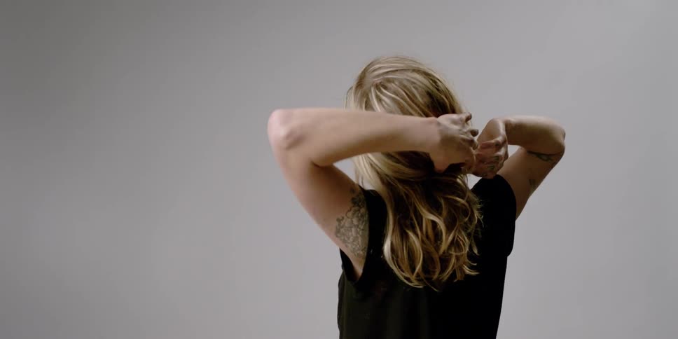 A woman is stretching and pulling at her hair
