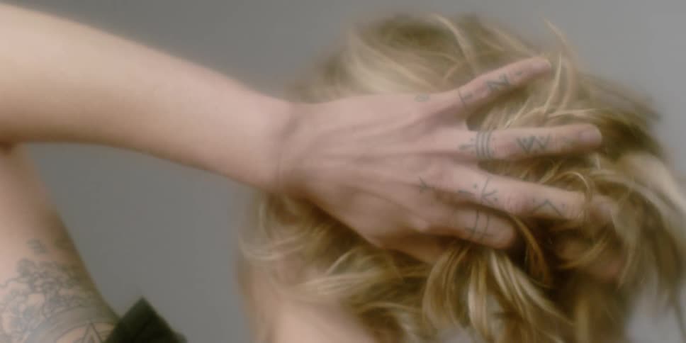 A woman brushes her blonde hair around