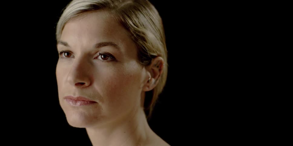 A woman is blinking and moving her head