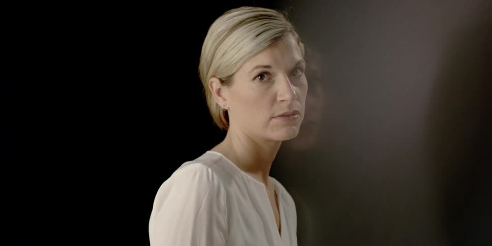 A woman slouches and stares toward the camera