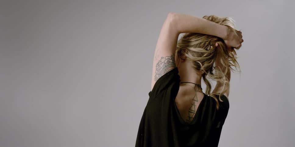 A woman stretches and lifts her hair off her neck