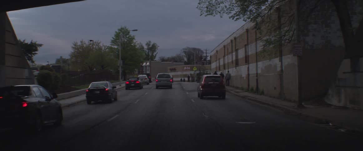 Large three lane street with cars making a stop