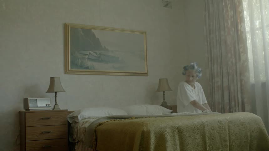 A woman is sitting in a bed by the window