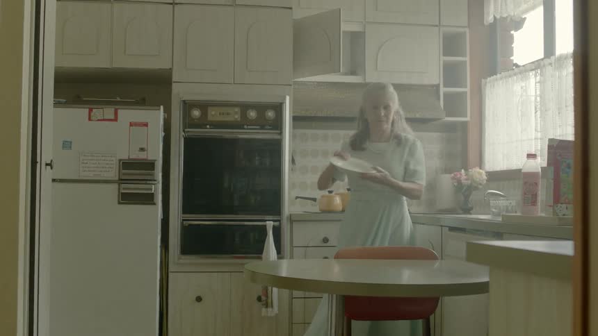 A woman removes dishes from her cupboard