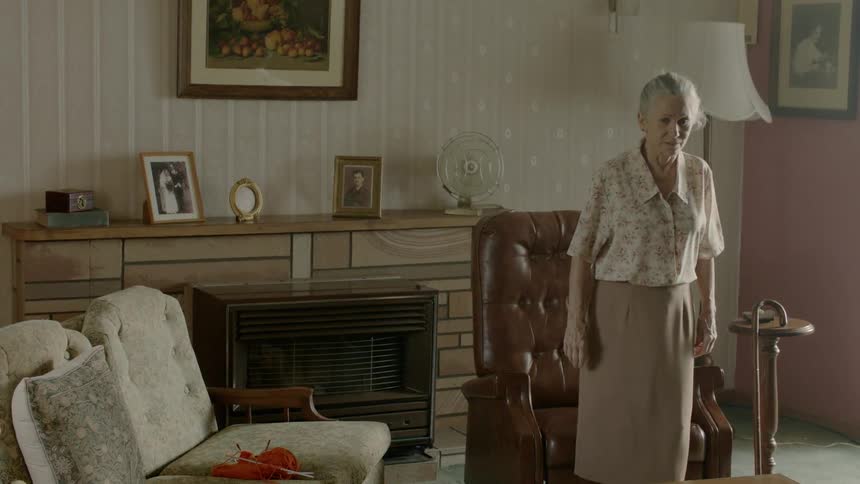 An old woman puts away her knitting and sits in another seat