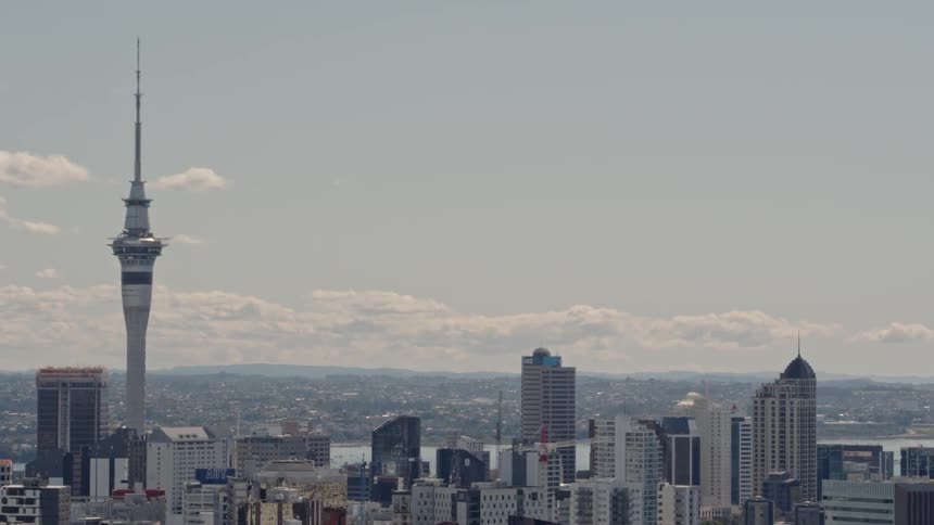A large city with a space needle is being filmed from a drone