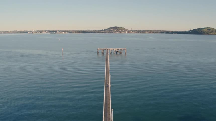 A pier juts out into a bay in a coastal community