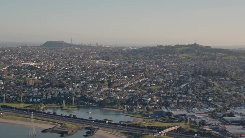 Cars commute in a city next to a lake