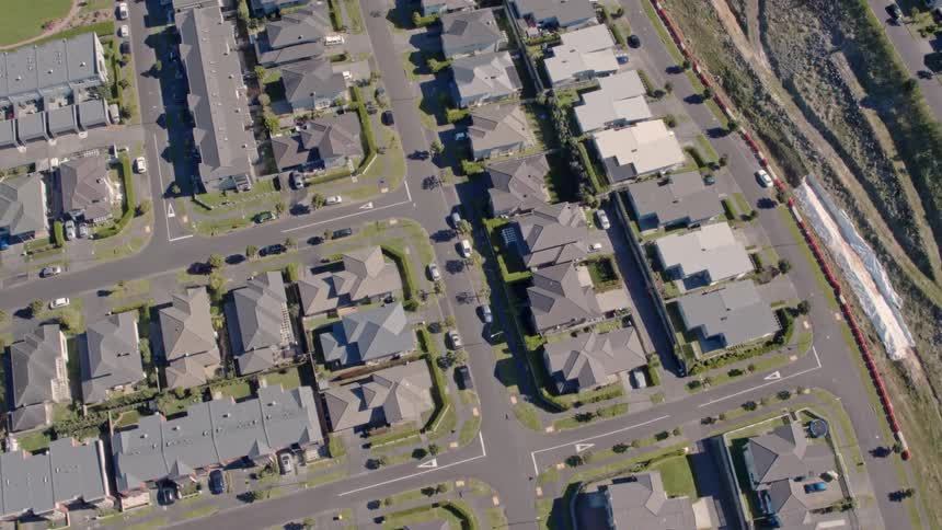 Vehicles drive along suburban streets
